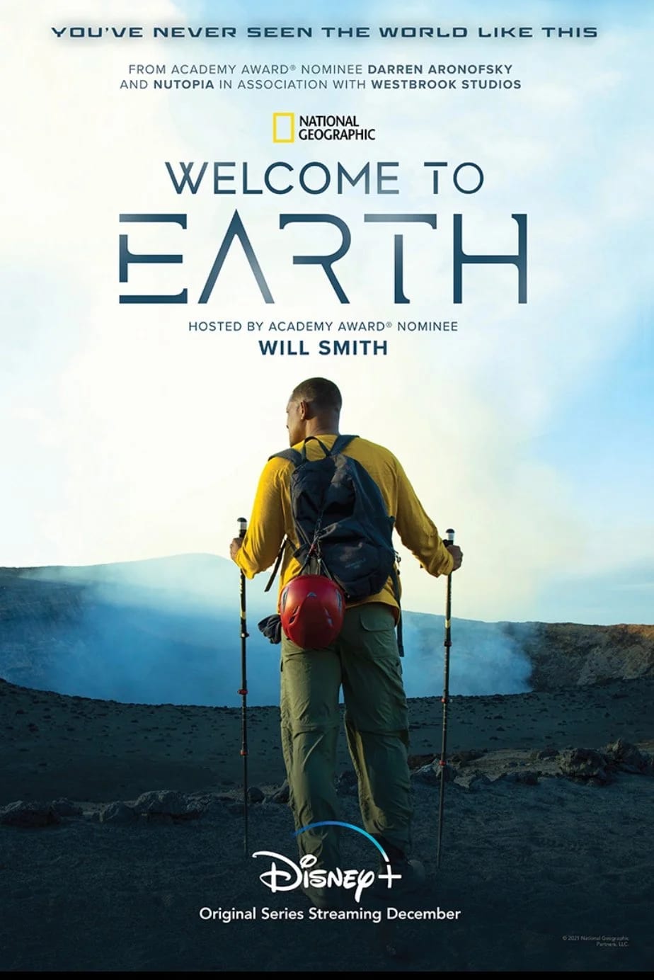 Poster for Welcome to Earth hosted by Will Smith, a hiker with poles and a red helmet walking toward a volcanic crater.
