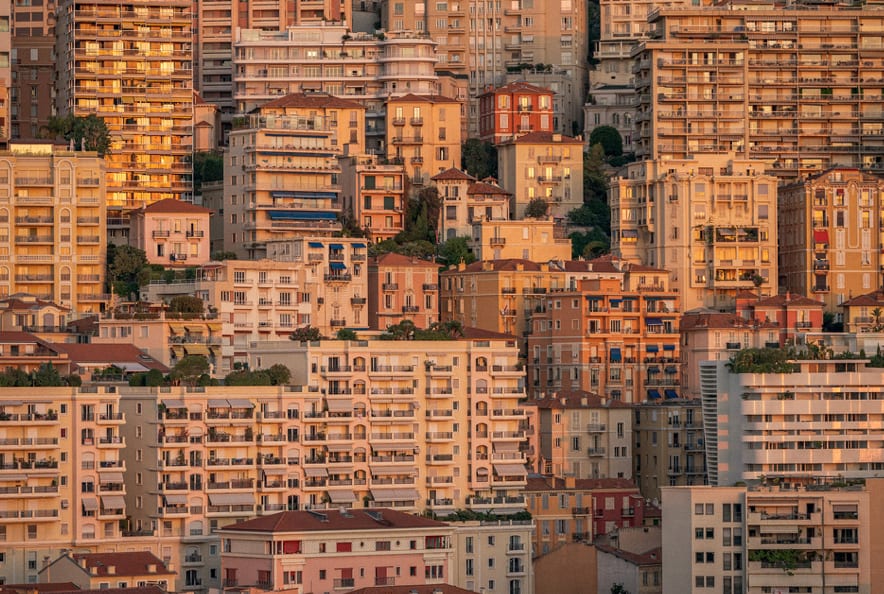 Dense hillside apartment buildings in warm evening light.